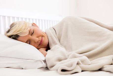 Woman sleeping peacefully with a cozy blanket