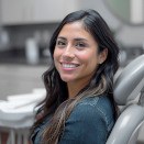 Smiling woman with dark hair in dental treatment chair