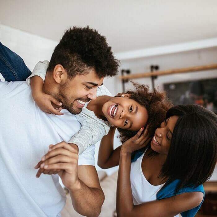 Family of three laughing in their living room