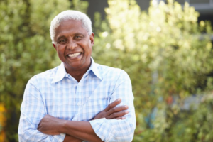 Man smiling confidently with trees in background